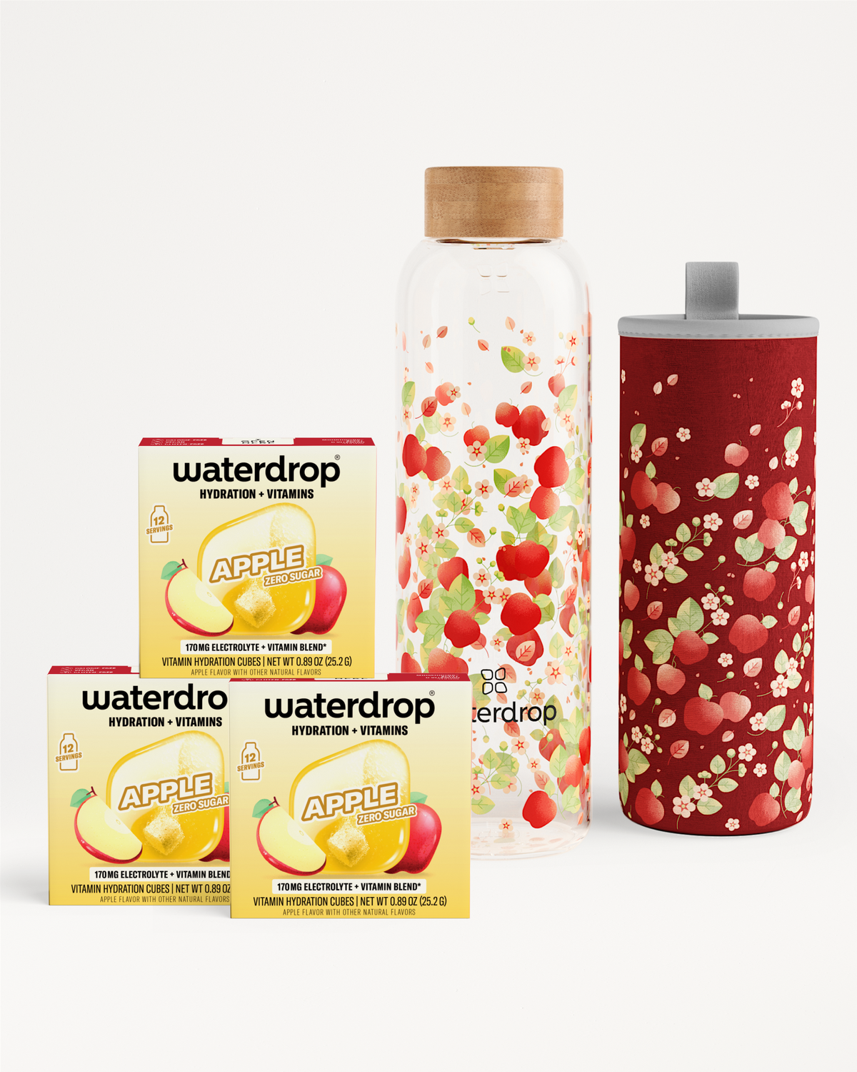 Three Waterdrop hydration vitamin boxes, a tall glass bottle with a wooden cap, and a red tumbler with a gray lid.