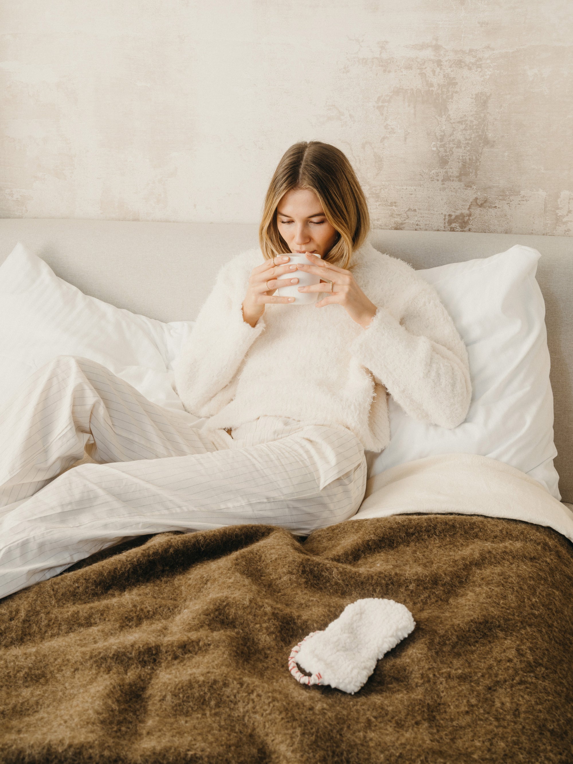 A woman laying on bed drinking waterdrop Microtea