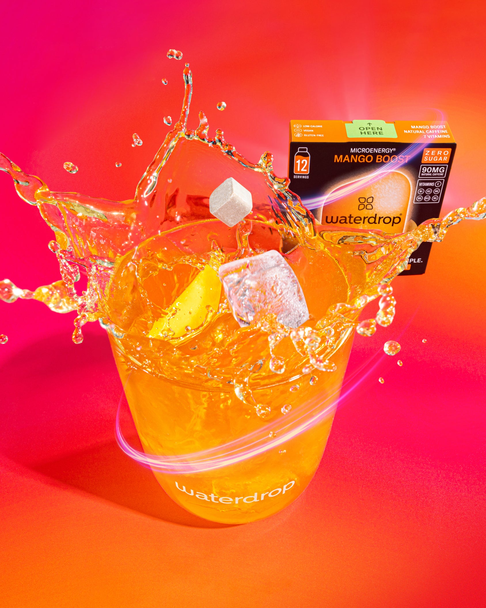 MANGO BOOST drink cube mid-splash with mango slice.
