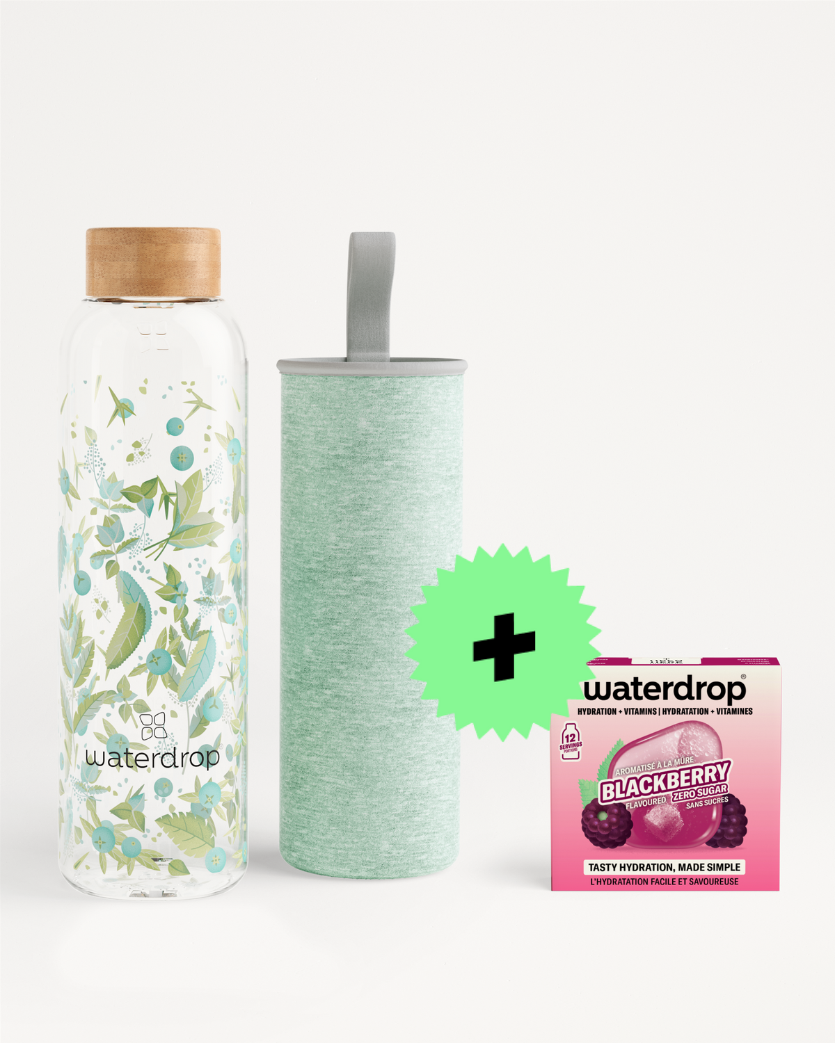 Glass water bottle with a floral pattern and wooden cap, a mint-green insulated bottle, and a small pink flavor-drops package.