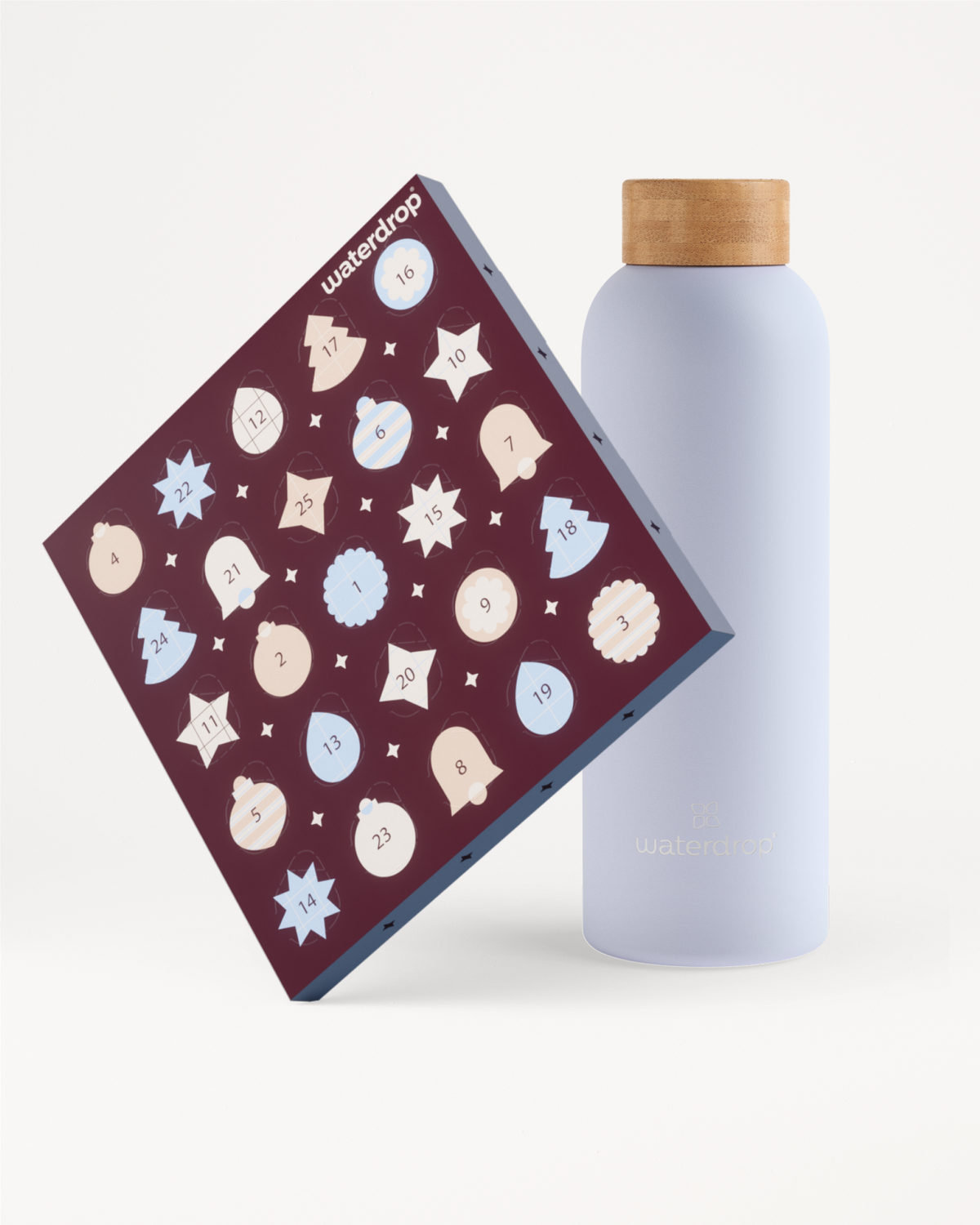 A dark red square box decorated with light icons leaning against a light lavender bottle with a wooden cap.