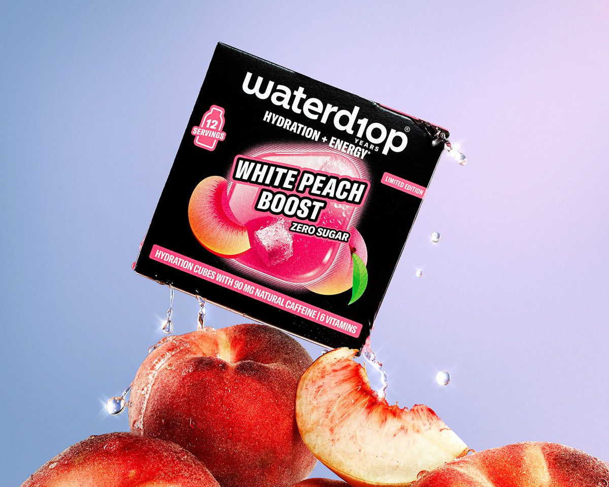 Boxed hydration- and energy-boosting product perched on peaches with water droplets, set against a pink-to-blue gradient background.