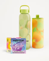 Two reusable water bottles with green caps and two hydration vitamin boxes in front.
