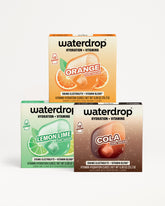 Three Waterdrop hydration and vitamins boxes stacked, with orange, lemon lime, and cola color accents.