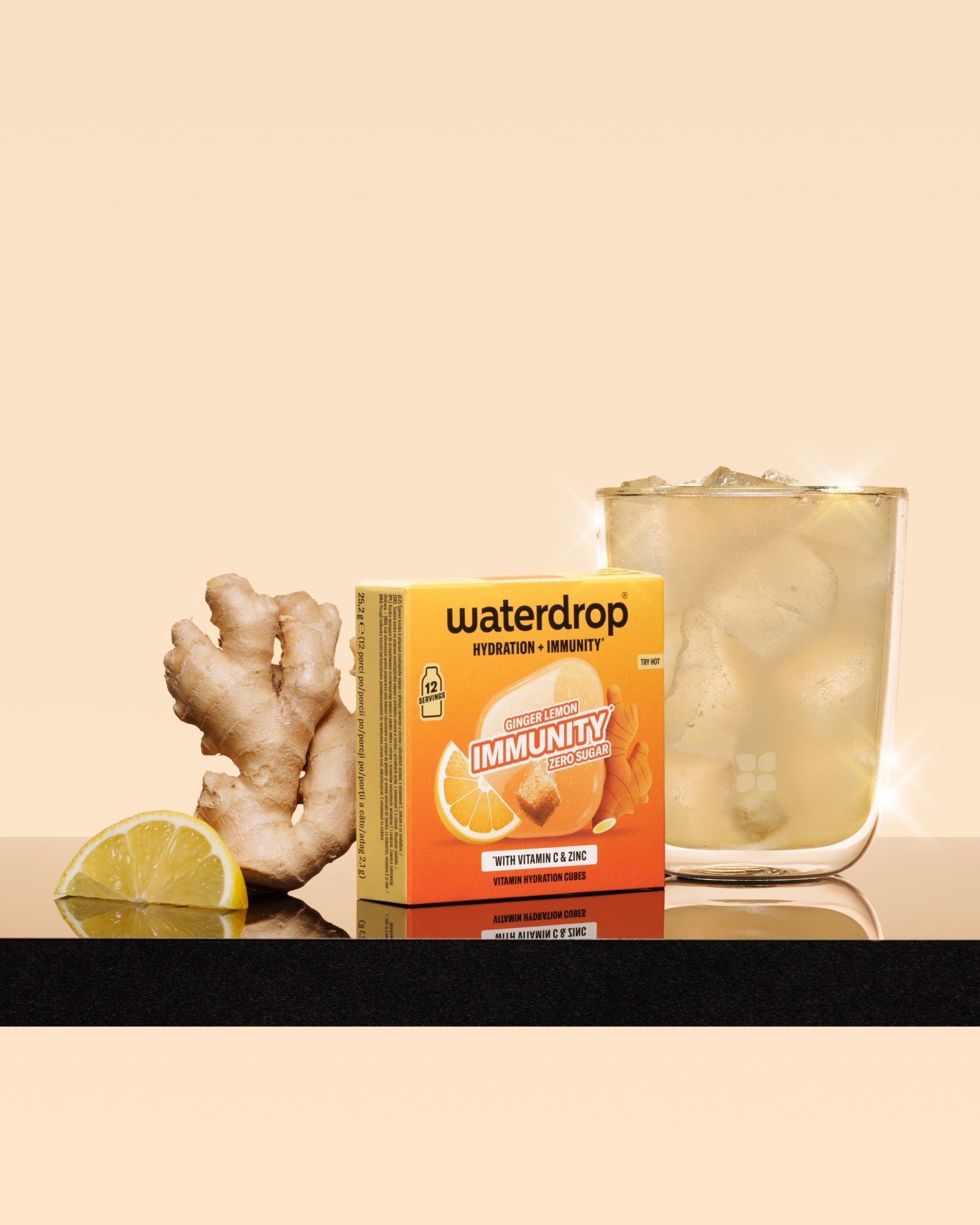 Boxed dietary supplement beside a lemon half, a piece of ginger, and a glass of iced drink.