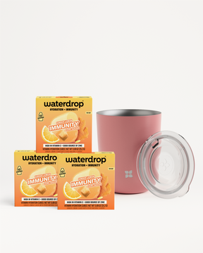 Three orange Waterdrop Immunity boxes beside a pink tumbler with a clear lid.